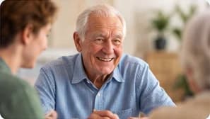 Un résident souriant discute avec une personne lors d'une animation